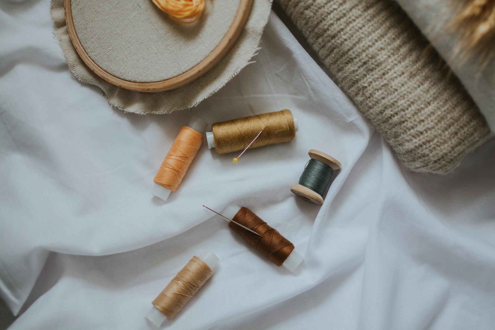 Studio table with threads, hoops and linen samples